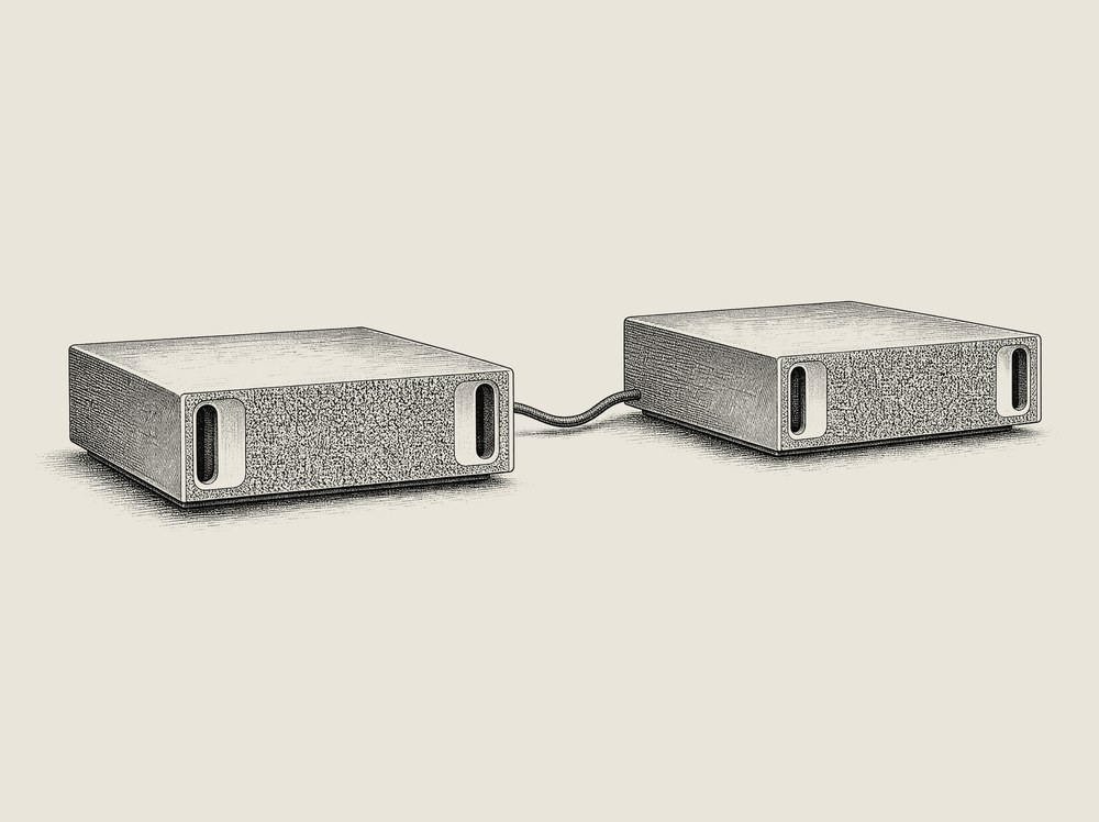 Engraved catalog illustration of two identical compact machines linked by a single cable.